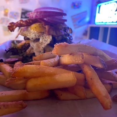 Burger mit Bacon und Pommes auf einem Tisch im Restaurant.
